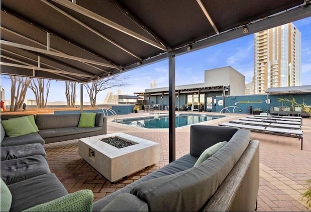 view of patio / terrace featuring an outdoor living space with a fire pit and a fenced in pool