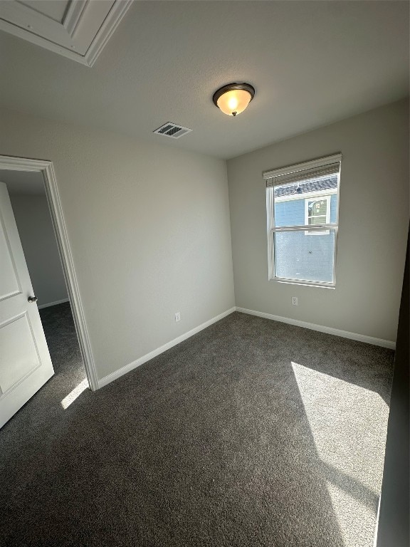 empty room with dark colored carpet