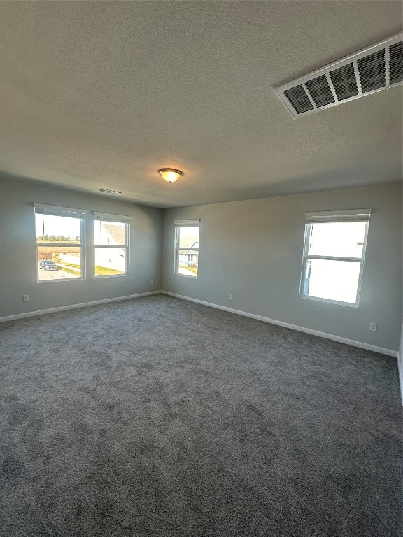 carpeted empty room with a textured ceiling