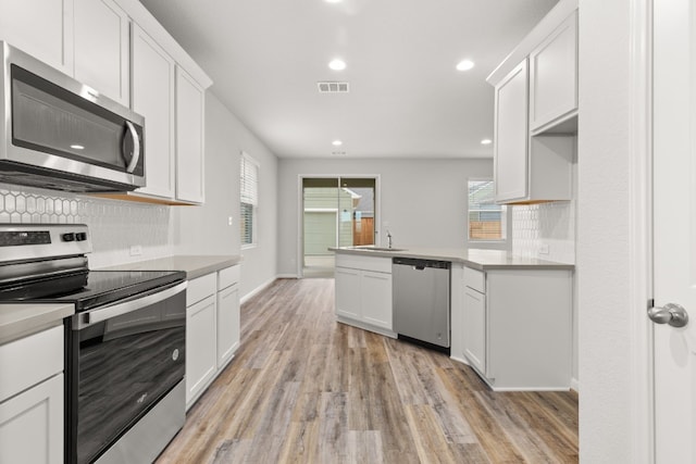 kitchen with white cabinetry, sink, light hardwood / wood-style flooring, and stainless steel appliances