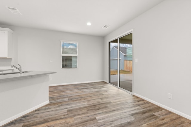 unfurnished dining area with sink and light hardwood / wood-style flooring