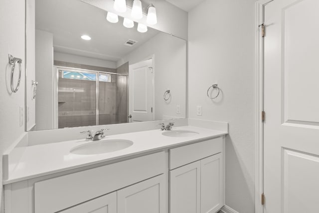 bathroom with vanity and a shower with shower door