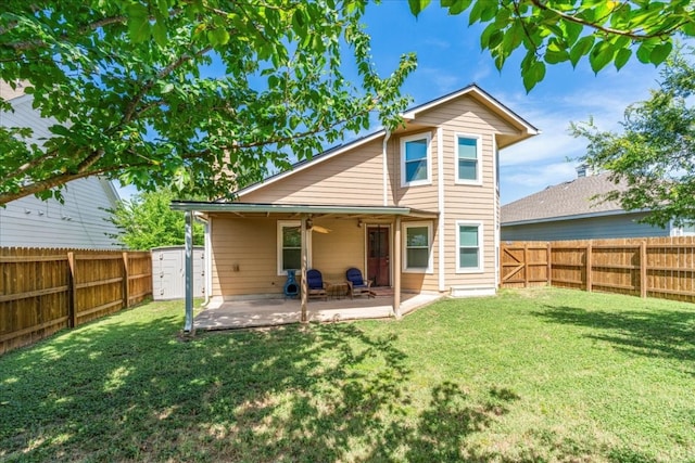 rear view of house with a patio and a lawn