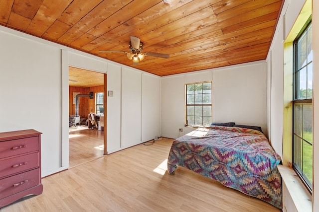 bedroom with wooden ceiling, light hardwood / wood-style floors, multiple windows, and ceiling fan