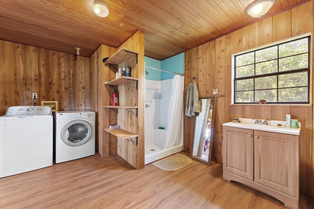 laundry room with light hardwood / wood-style floors, separate washer and dryer, wooden ceiling, and wooden walls