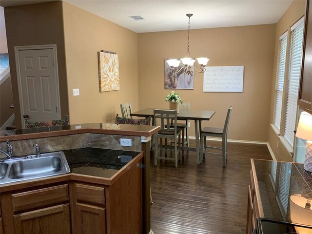 kitchen with hanging light fixtures, sink, dark hardwood / wood-style flooring, and an inviting chandelier