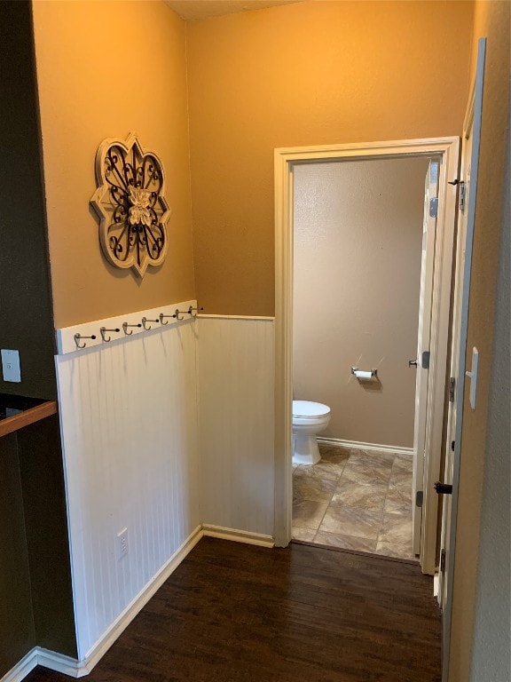 bathroom featuring toilet and wood-type flooring