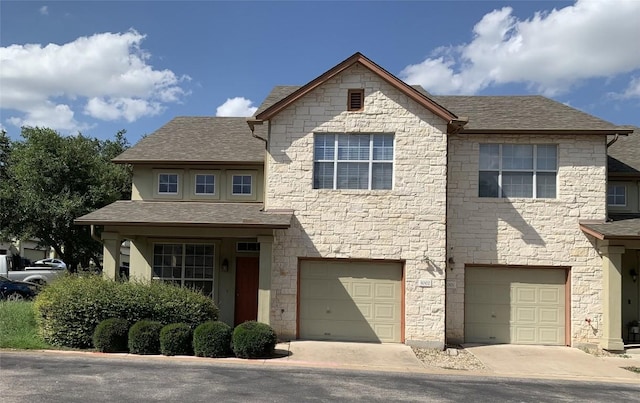 view of front facade featuring a garage, driveway, and a shingled roof