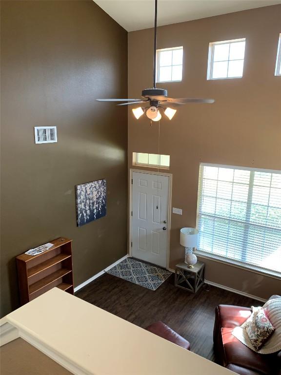 entrance foyer featuring a healthy amount of sunlight, a high ceiling, visible vents, and wood finished floors