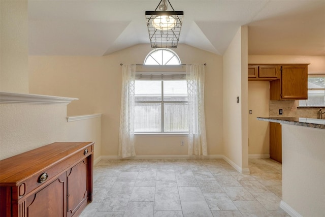 unfurnished dining area with vaulted ceiling