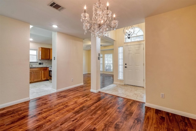 entrance foyer featuring a notable chandelier, light hardwood / wood-style floors, and a wealth of natural light