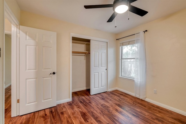 unfurnished bedroom featuring dark hardwood / wood-style flooring, a closet, and ceiling fan