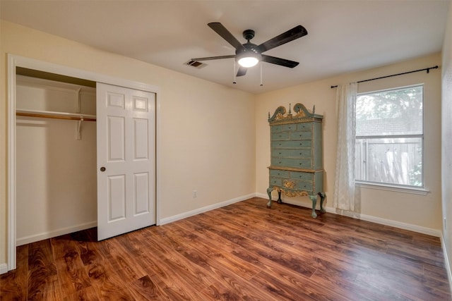 unfurnished bedroom with dark hardwood / wood-style flooring, a closet, and ceiling fan