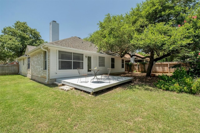 back of property featuring a lawn and a deck