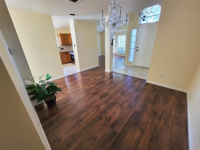 entryway with hardwood / wood-style floors and a notable chandelier