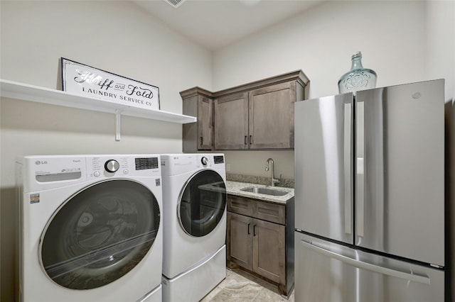 washroom featuring cabinets, washer and clothes dryer, and sink