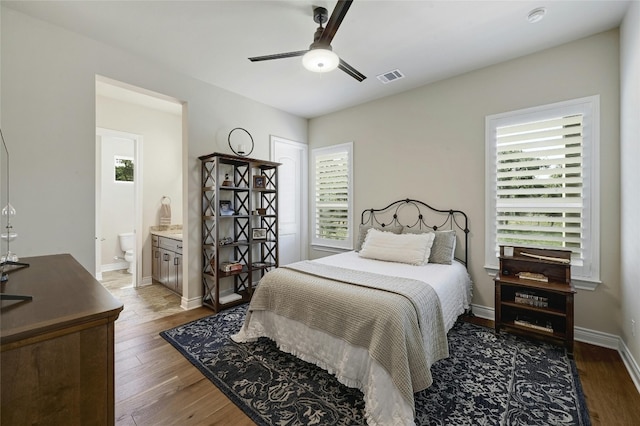 bedroom featuring multiple windows, ceiling fan, and dark hardwood / wood-style flooring