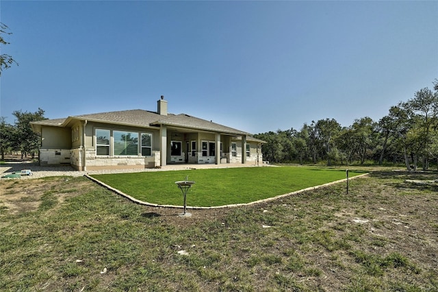 rear view of property featuring a yard