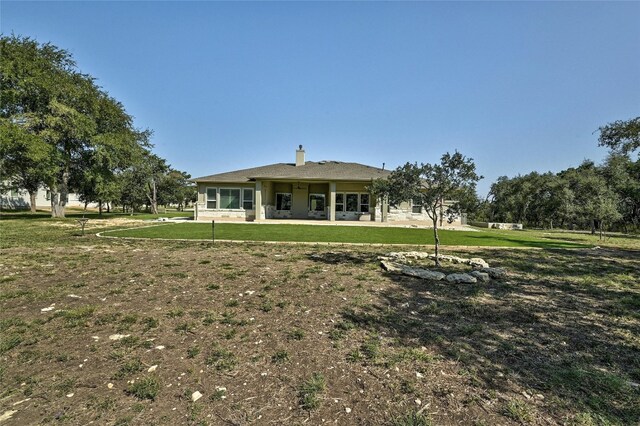 rear view of property with a yard