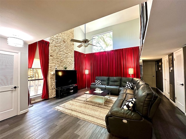 living room featuring ceiling fan, dark hardwood / wood-style floors, and a high ceiling