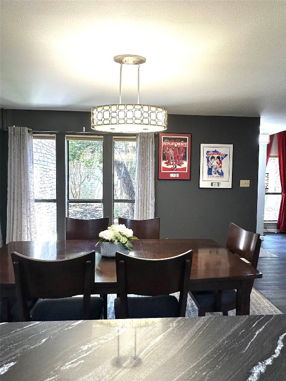 dining room with a textured ceiling and wood-type flooring