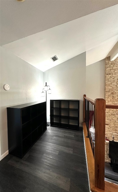 interior space featuring lofted ceiling with beams and dark hardwood / wood-style flooring