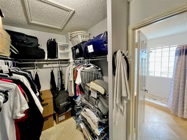 13242 Kerrville Folkway, Austin, TX 78729 - walk in closet featuring attic access and tile patterned floors