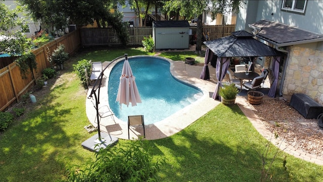 view of swimming pool featuring a gazebo, a storage unit, and a yard