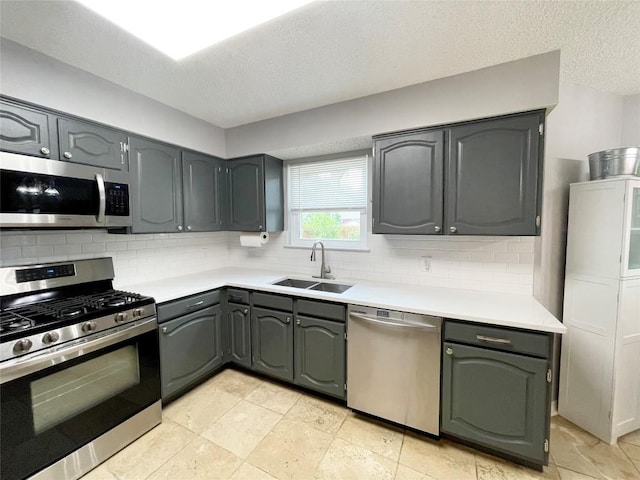 13242 Kerrville Folkway, Austin, TX 78729 - kitchen featuring stainless steel appliances, a sink, light countertops, decorative backsplash, and a textured ceiling
