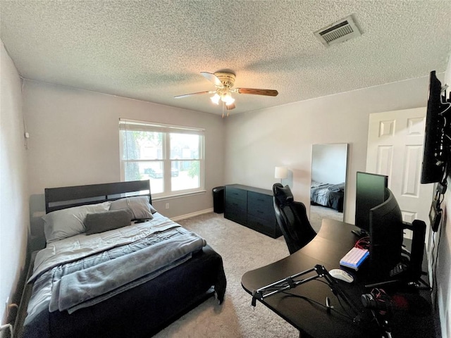 carpeted bedroom featuring a textured ceiling and ceiling fan