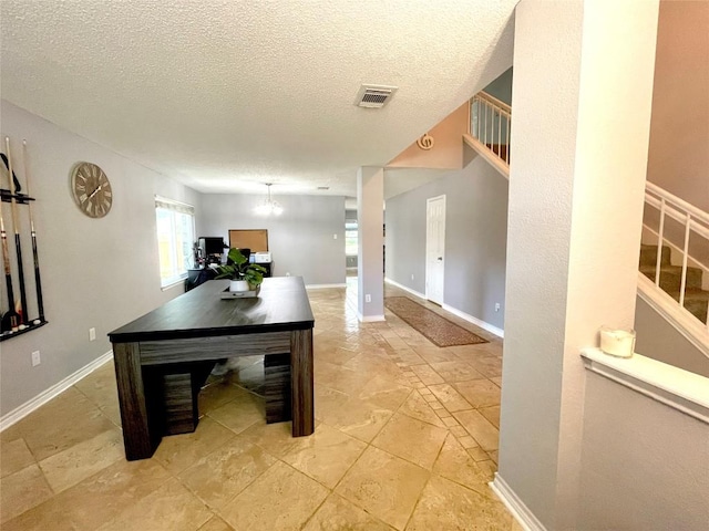 interior space with a notable chandelier and a textured ceiling