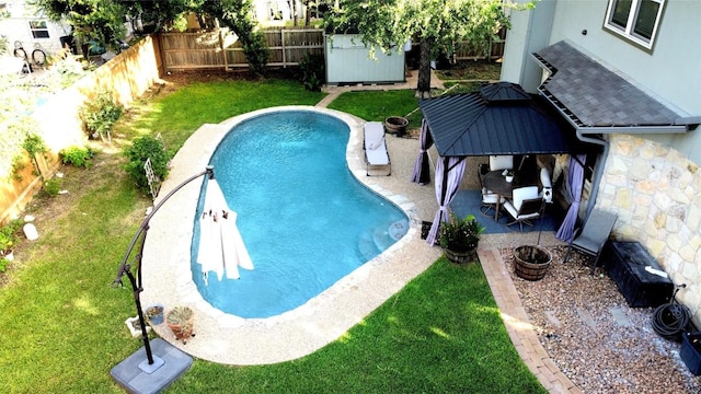 view of swimming pool with a storage shed, a gazebo, a patio, and a yard