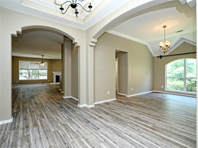 spare room featuring lofted ceiling, an inviting chandelier, crown molding, hardwood / wood-style flooring, and a tray ceiling