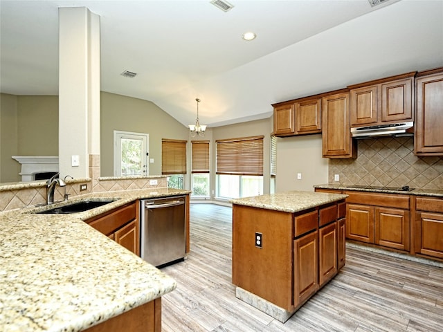 kitchen with pendant lighting, dishwasher, vaulted ceiling, tasteful backsplash, and a kitchen island