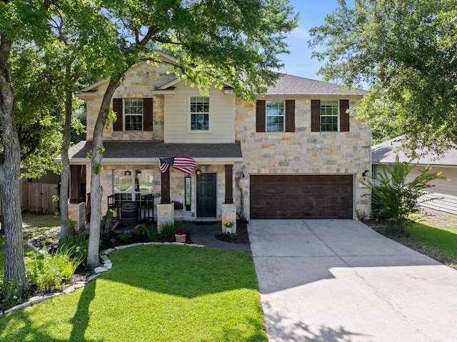 view of front of home with a porch, a front yard, and a garage