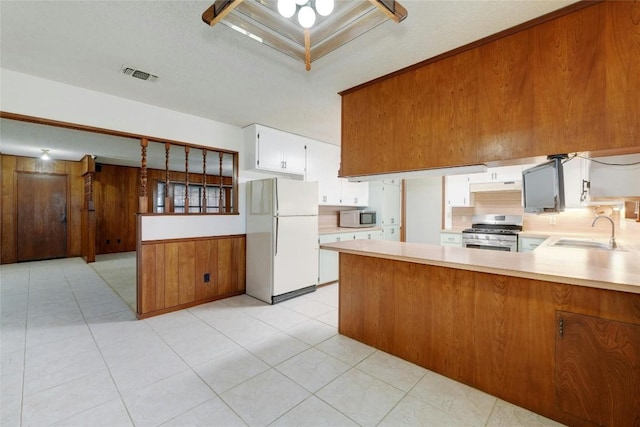 kitchen featuring sink, white cabinetry, tasteful backsplash, kitchen peninsula, and stainless steel appliances