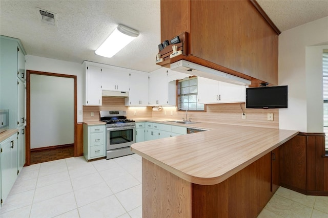 kitchen with a textured ceiling, white cabinetry, sink, kitchen peninsula, and gas range