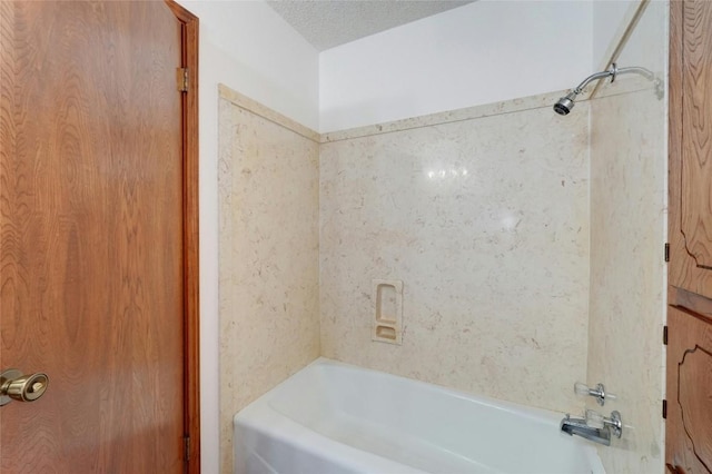 bathroom featuring a textured ceiling and  shower combination