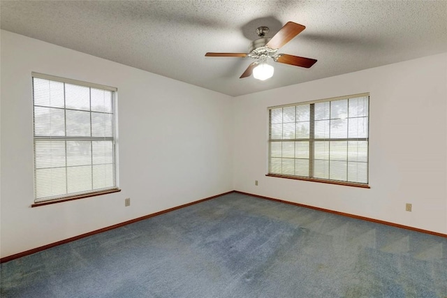 empty room with ceiling fan, carpet floors, and a textured ceiling