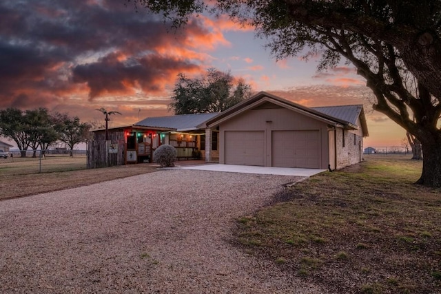 ranch-style house featuring a garage and a yard