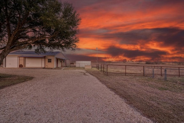 yard at dusk featuring a garage