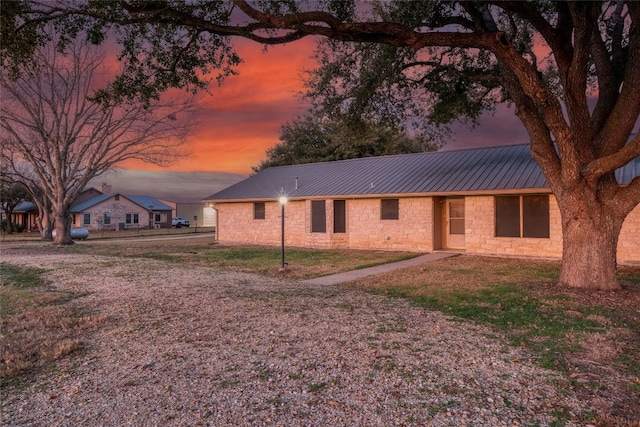 back house at dusk with a lawn