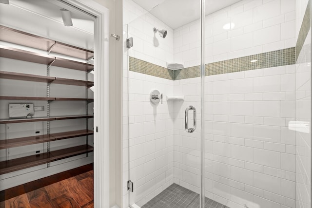 bathroom featuring wood-type flooring and an enclosed shower