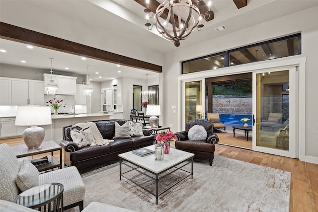 living room featuring light hardwood / wood-style floors, sink, and a chandelier