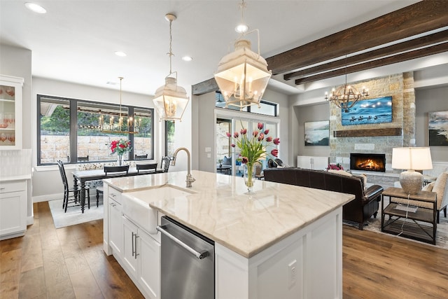 kitchen with white cabinets, wood-type flooring, a kitchen island with sink, and stainless steel dishwasher