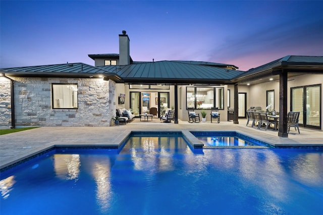 pool at dusk featuring a patio area