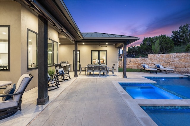 pool at dusk featuring a patio, an in ground hot tub, and ceiling fan