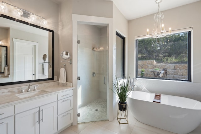 bathroom featuring tile patterned flooring, plus walk in shower, a wealth of natural light, and vanity