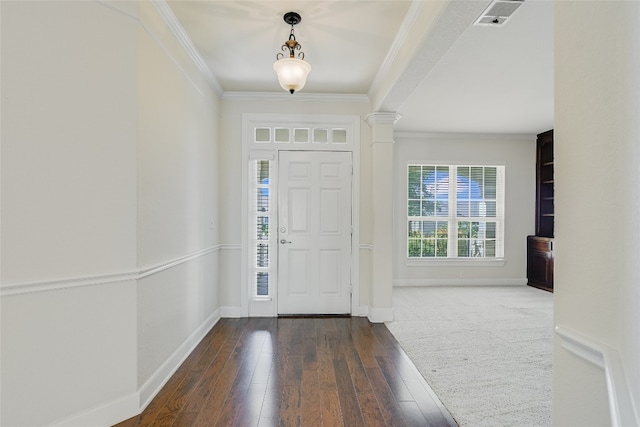 entryway with crown molding, dark hardwood / wood-style flooring, and ornate columns