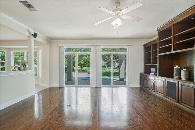 unfurnished living room featuring ceiling fan, dark hardwood / wood-style flooring, and ornamental molding